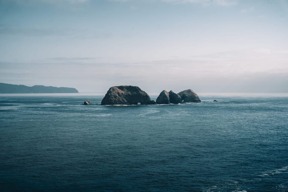 Moody ocean view with distant rocky islands under an overcast sky